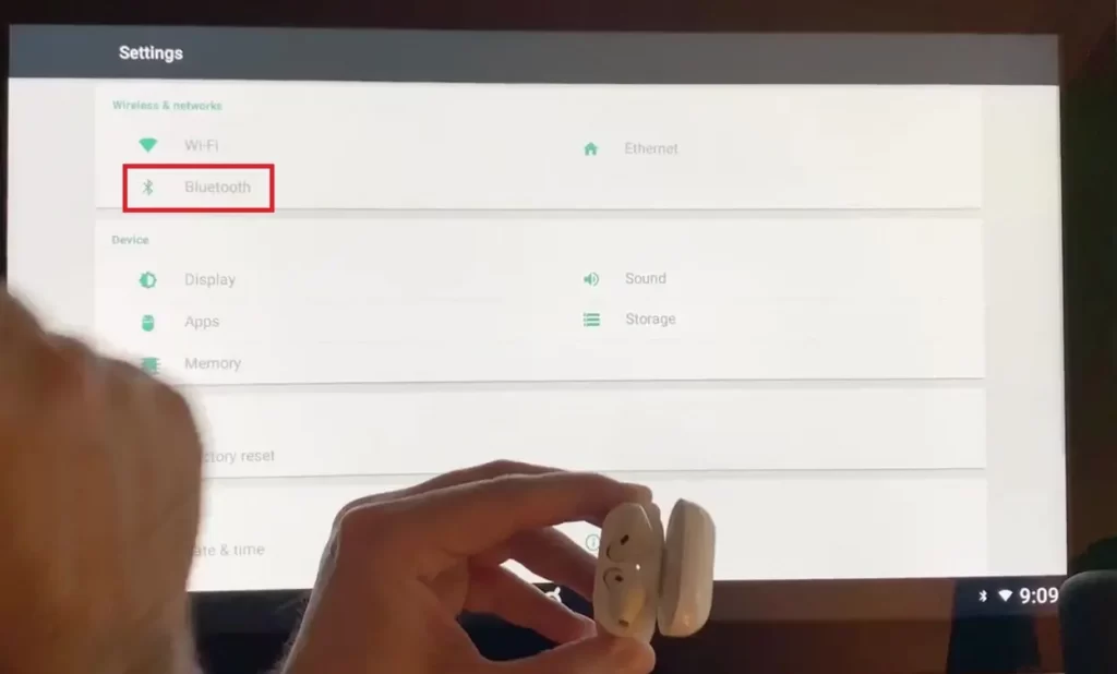 Bluetooth highlighted on the Settings screen on Peloton Display. Airpods ready to connect in pairing mode.